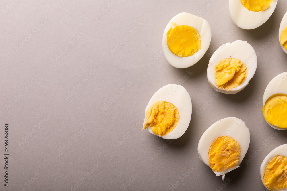 Directly above view of fresh white eggs boiled with yellow yolks by copy space on gray background Directly above view of fresh white eggs boiled with yellow yolks by copy space on gray background
