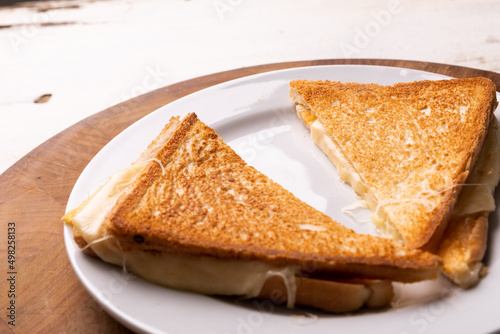 High angle view of fresh cheese sandwich served in plate on wooden serving board