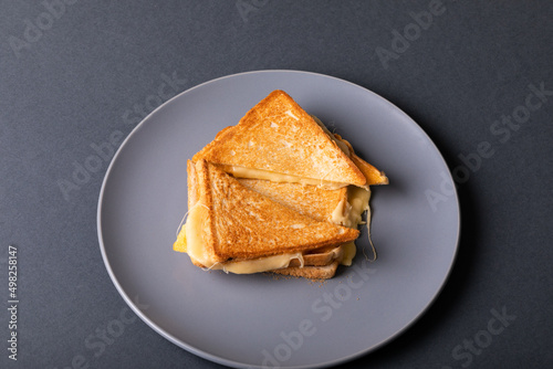 Directly above view of fresh cheese toast sandwich served in plate on blue background