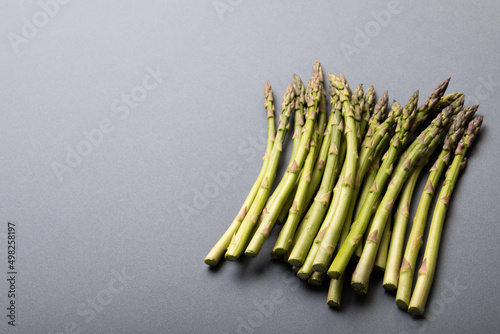 High angle view of fresh green asparagus on gray background with copy space