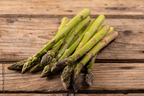 Close-up of raw green asparagus on wooden brown table