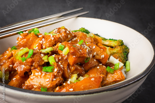 Delicious sweet chopping chicken rice, sesame seeds and sliced spring onions, broccoli, vegetables with chopsticks. Asian food, Japanese food copy space for your text