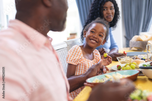 African american smiling cute girl having lunch with family at home on thanksgiving day