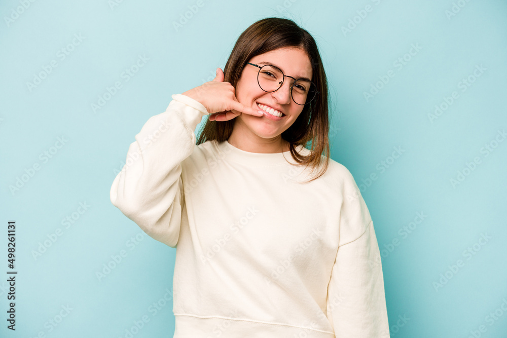 Young caucasian woman isolated on blue background showing a mobile phone call gesture with fingers. Young caucasian woman isolated on blue background showing a mobile phone call gesture with fingers.
