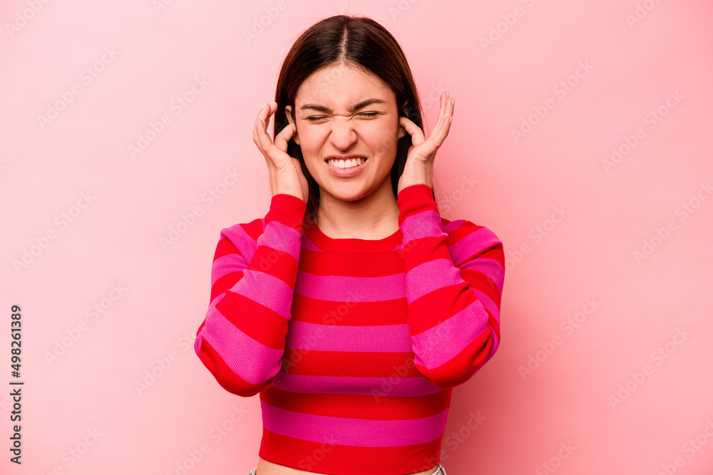 Young caucasian woman isolated on pink background covering ears with hands. Young caucasian woman isolated on pink background covering ears with hands.