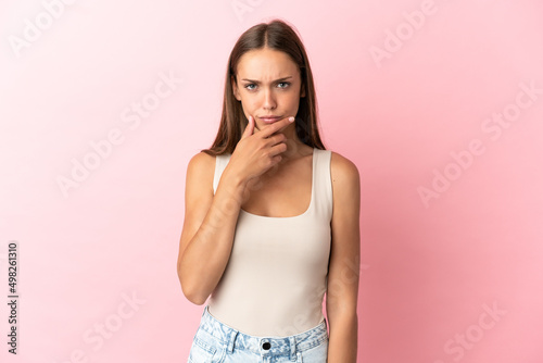 Young woman over isolated pink background thinking