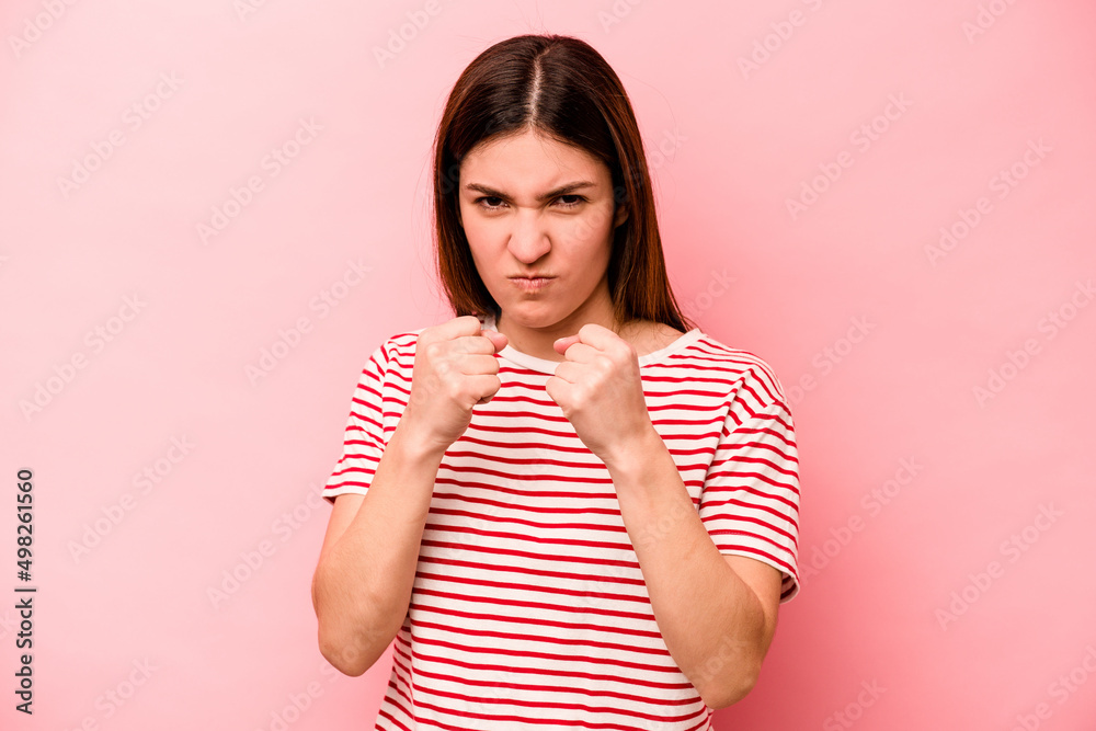 Young caucasian woman isolated on pink background showing fist to camera, aggressive facial expression. Young caucasian woman isolated on pink background showing fist to camera, aggressive facial expression.