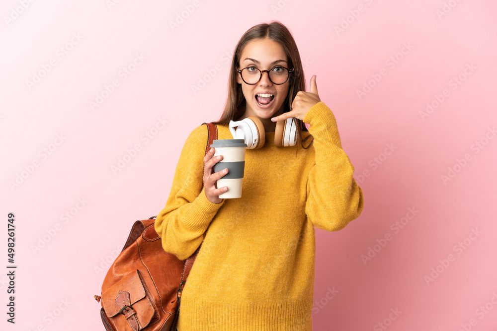 Young student woman over isolated pink background making phone gesture. Call me back sign Young student woman over isolated pink background making phone gesture. Call me back sign