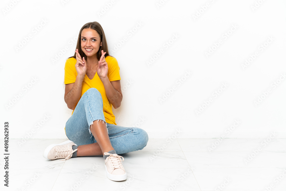 Young girl sitting on the floor with fingers crossing
