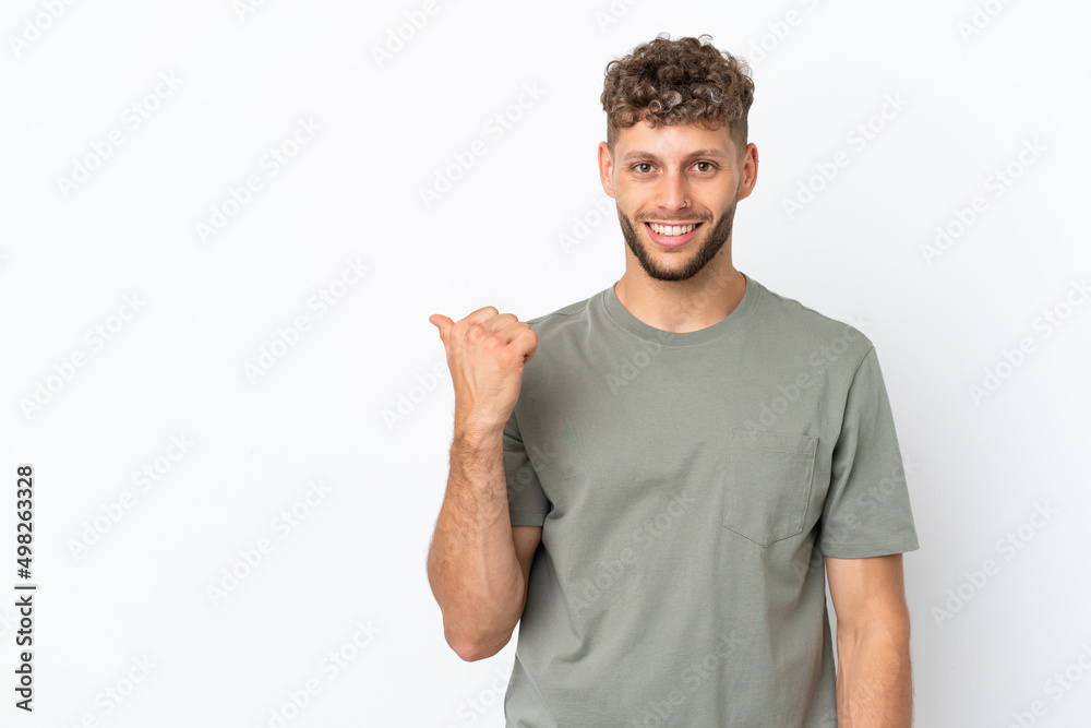 Young caucasian handsome man isolated on white background pointing to the side to present a product Young caucasian handsome man isolated on white background pointing to the side to present a product