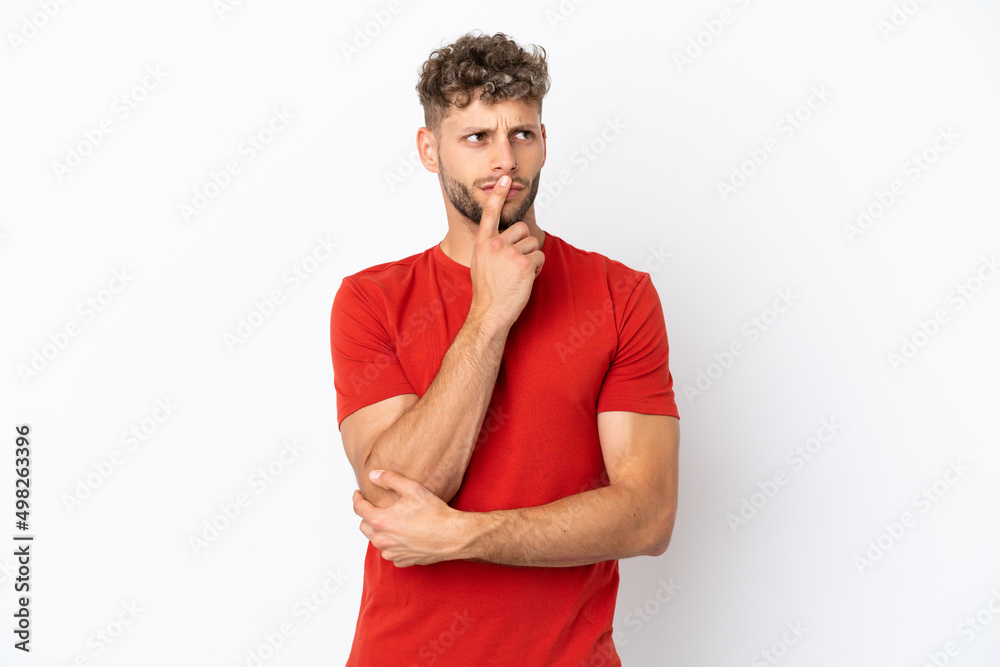 Young caucasian handsome man isolated on white background having doubts while looking up Young caucasian handsome man isolated on white background having doubts while looking up