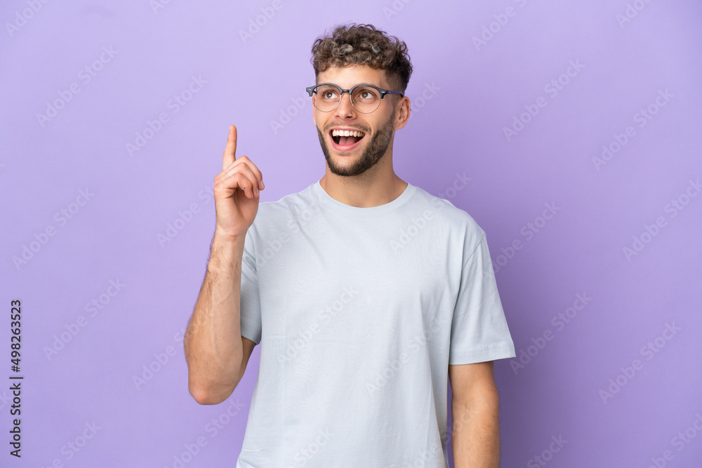 Delivery caucasian man isolated on purple background pointing up and surprised Delivery caucasian man isolated on purple background pointing up and surprised