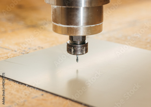 CNC drilling machine is working with metal plate. Close-up