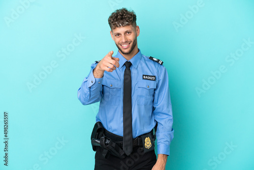 Young police blonde man isolated white on blue background points finger at you with a confident expression