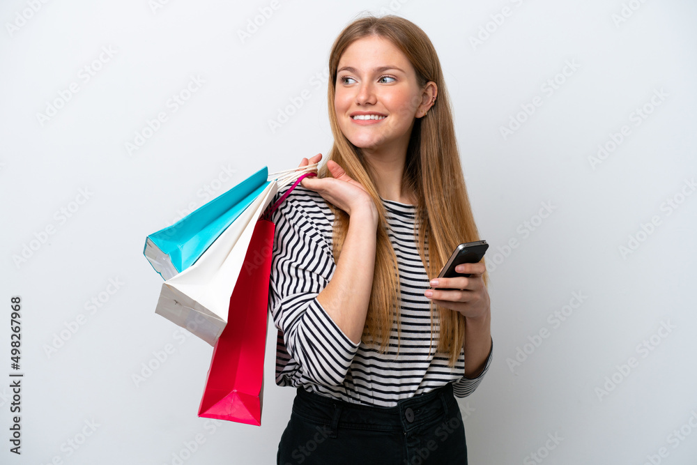 Young caucasian woman isolated on white background holding shopping bags and a mobile phone Young caucasian woman isolated on white background holding shopping bags and a mobile phone