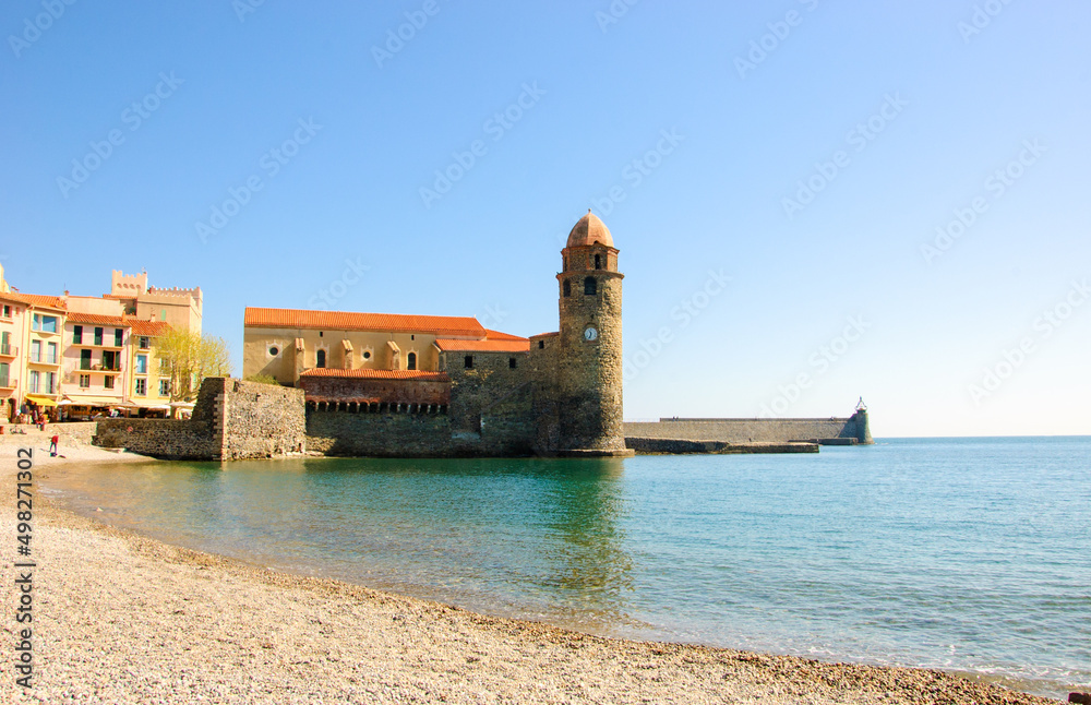 Collioure, France. Beach landscape and Church of Our Lady of Angels in port at background . Picturesque Collioure is popular tourist travel destination.