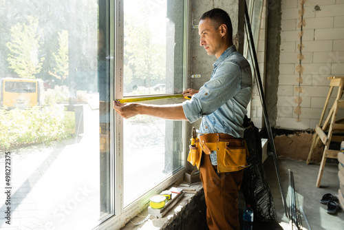 Wallpaper Mural Construction worker installing window in house Torontodigital.ca