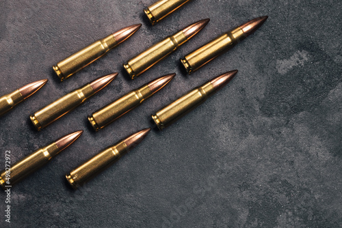 Bullets on gray background. Cartridges 7.62 caliber for Kalashnikov assault rifle. Top view, flat lay with copy space