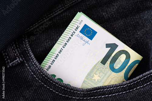 A hundred euro banknote sticks out of a jeans pocket. Financial, savings and exchange business background background.
