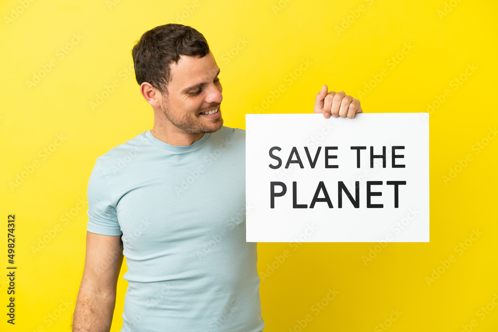 Brazilian man over isolated purple background holding a placard with text Save the Planet Brazilian man over isolated purple background holding a placard with text Save the Planet