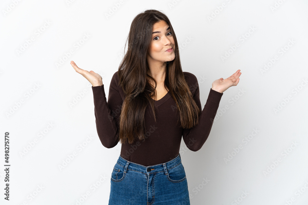 Teenager Brazilian girl isolated on white background having doubts while raising hands Teenager Brazilian girl isolated on white background having doubts while raising hands
