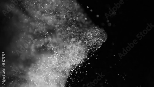 White dynamic dust particles in motion on black background photo