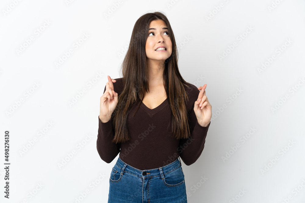 Teenager Brazilian girl isolated on white background with fingers crossing and wishing the best Teenager Brazilian girl isolated on white background with fingers crossing and wishing the best
