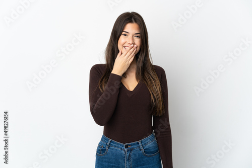 Teenager Brazilian girl isolated on white background happy and smiling covering mouth with hand