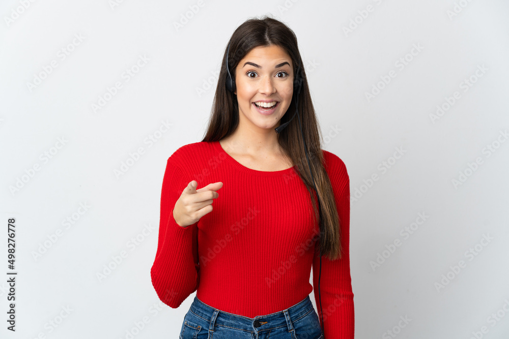 Young Brazilian telemarketer girl over isolated background surprised and pointing front Young Brazilian telemarketer girl over isolated background surprised and pointing front