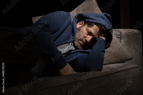 Senior Mann mit Migräne oder Depressionen hat sich einsam im dunkeln auf seine Couch zurück gezogen. © patrickjohn71
