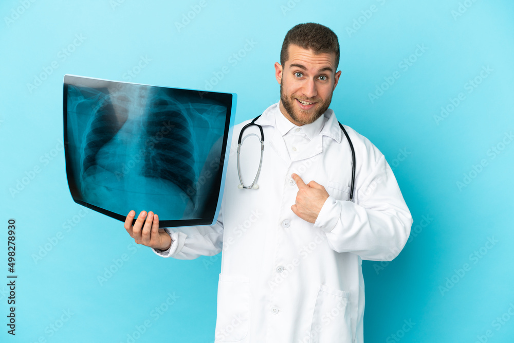 Professional traumatologist isolated on blue background with surprise facial expression Professional traumatologist isolated on blue background with surprise facial expression