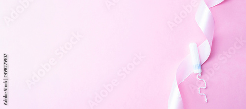 Menstrual tampon feminine hygiene. Pink ribbon with menstrual tampon on pink background. Menstruation feminine period. Sanitary hygiene concept. Medical healthcare gynecological banner.