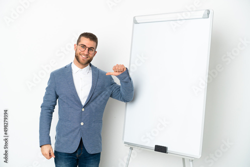 Young business woman giving a presentation on white board isolated on white background proud and self-satisfied