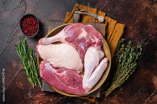 Fotografia Fresh duck meat parts, raw breast steak, legs, wings in a plate with herbs