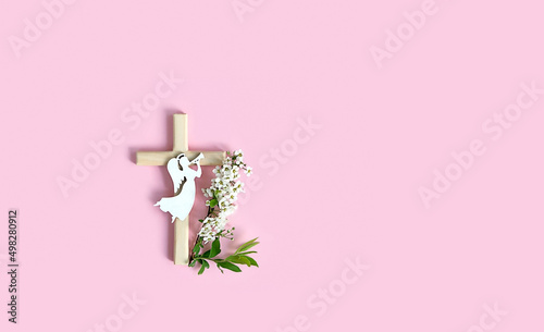 Leinwand Poster wooden christianity cross, angel and flowers on pink background