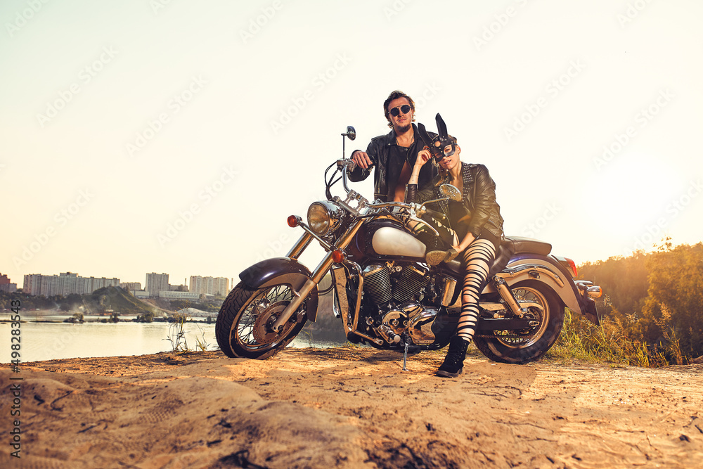 Obraz premium Sexy couple of bikers on the vintage custom motorcycle, girl in a rabbit mask