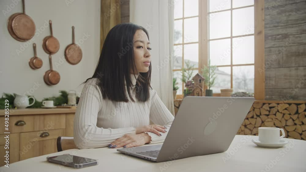 Portrait of a young woman turning her head and smiling in front of her laptop Portrait of a young woman turning her head and smiling in front of her laptop
