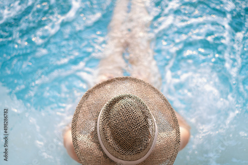 Young Asian woman relaxing in swimming pool at a spa resort Koh Larn Pattaya. relaxing and holiday concept.Top view close up
