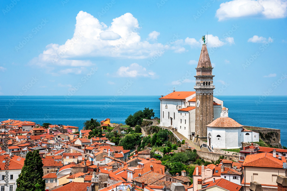 Beautiful landscape with a spire of Saint George's Church and tiled roofs and the whole part of the city Piran, Slovenia. Amazing places.