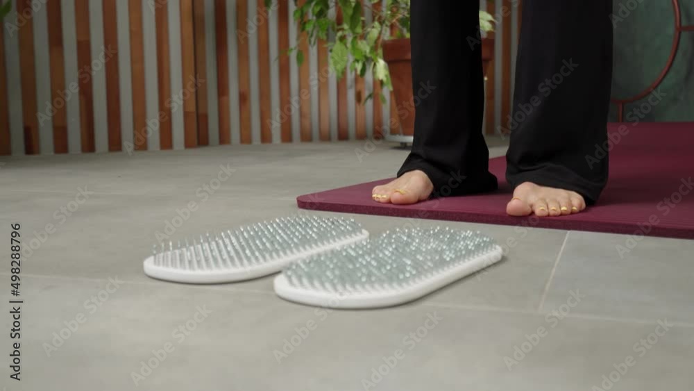 стопы человека стоящего на коврике для йоги