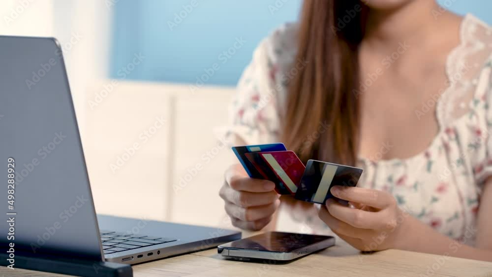 4K 50fps, A beautiful Asian girl, sitting and choosing a credit card to pay for online purchases via mobile phone back and forth, is very stressful.online shhopping.
