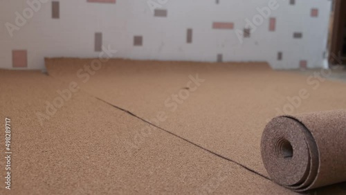 Roll of wood cork. roll of suberic wood. roll of cork wood on the floor for laminate. Unroll Natural Cork roll on the floor. basis for a Laminate photo