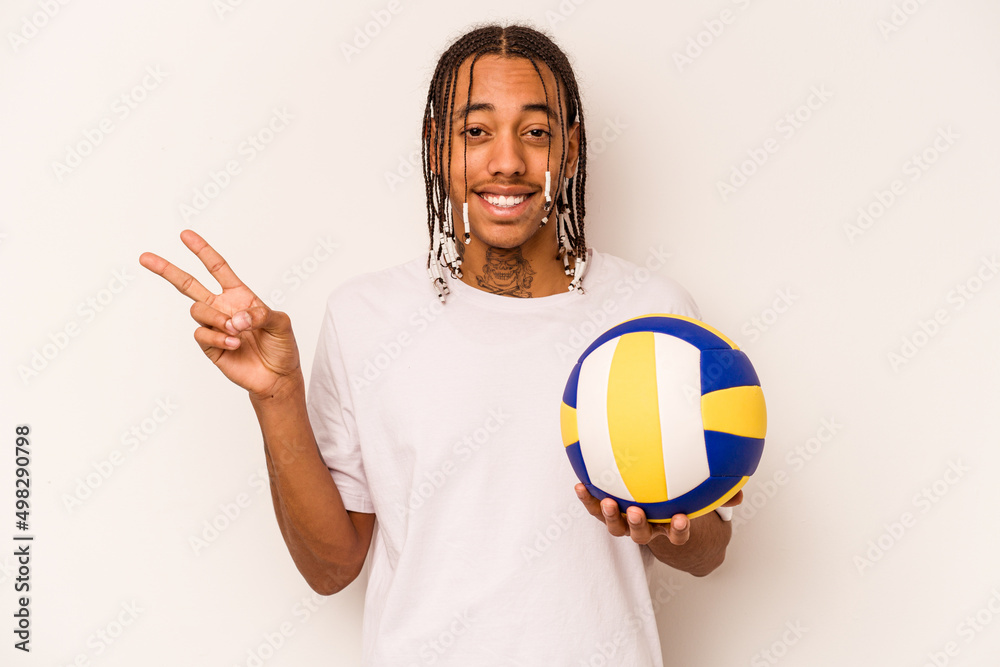 Young African American man playing volleyball isolated on white background joyful and carefree showing a peace symbol with fingers.