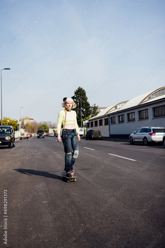 Young nonconformist real beauty queer woman skating outdoors riding skateboard Young nonconformist real beauty queer woman skating outdoors riding skateboard