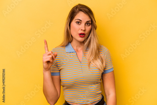 Young caucasian woman isolated on yellow background pointing upside with opened mouth.