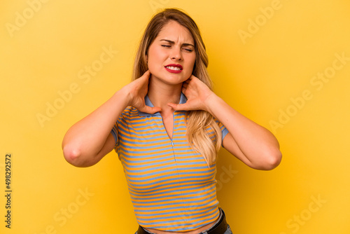 Young caucasian woman isolated on yellow background suffering neck pain due to sedentary lifestyle.