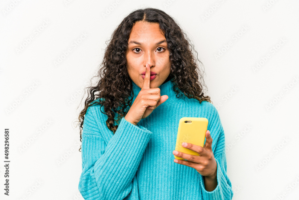 Young hispanic woman holding mobile phone isolated on white background keeping a secret or asking for silence. Young hispanic woman holding mobile phone isolated on white background keeping a secret or asking for silence.