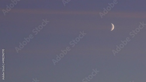 Crescent moon and dark night sky. Mysterious and moody nature scene with copy space. photo