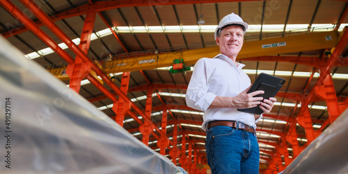 Portrait professional Design civil engineer wearing safety hardhat helmet holding digital tablet computer in large Industrial Factory. Small business owner.