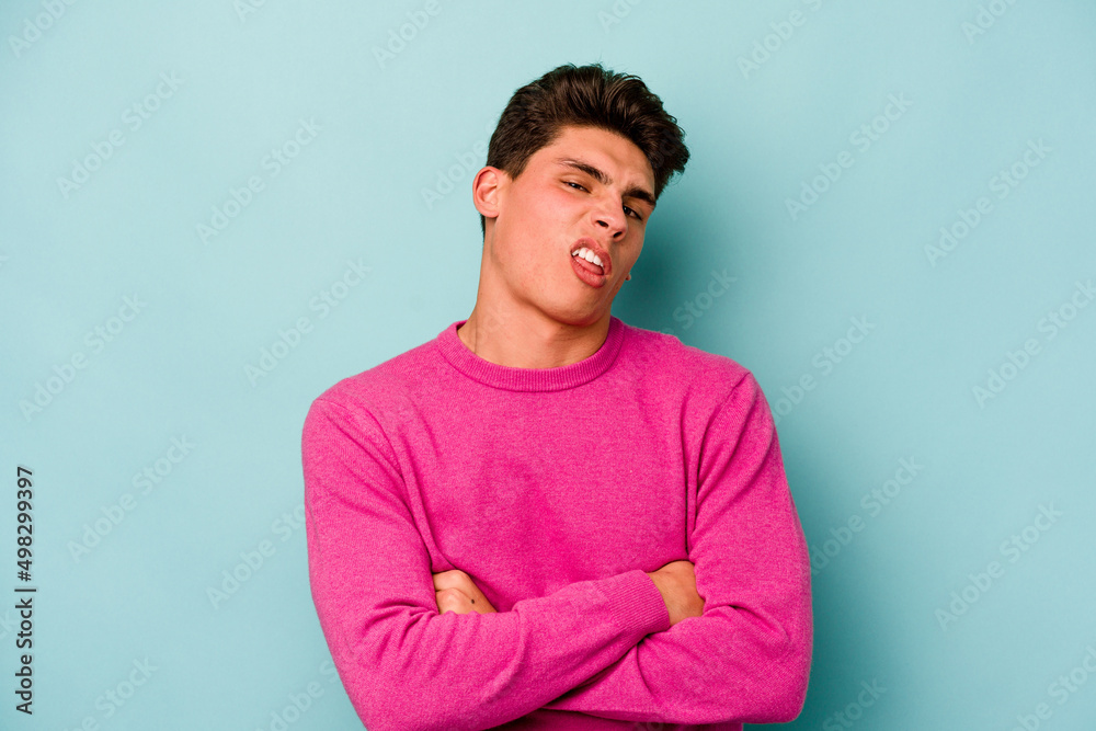 Young caucasian man isolated on blue background who is bored, fatigued and need a relax day. Young caucasian man isolated on blue background who is bored, fatigued and need a relax day.